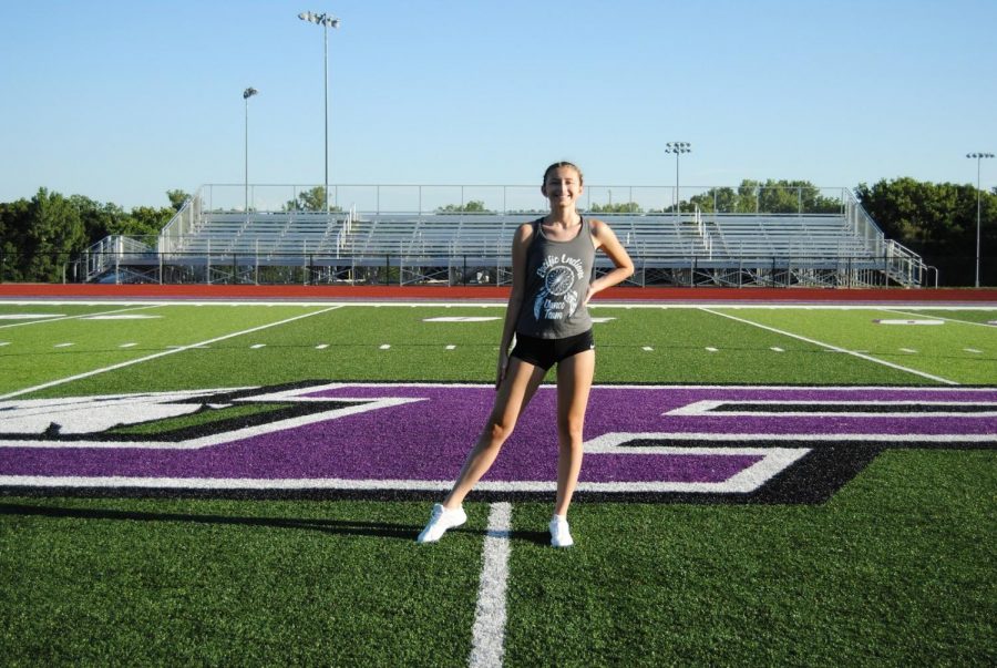 Erin Brooks stands on the athletic field